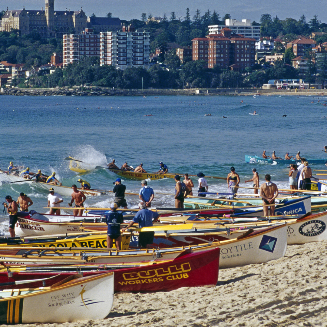 2 Lifesavers prepping for a surf boat race – the vibrant coastal life Manly buyers agents know well.