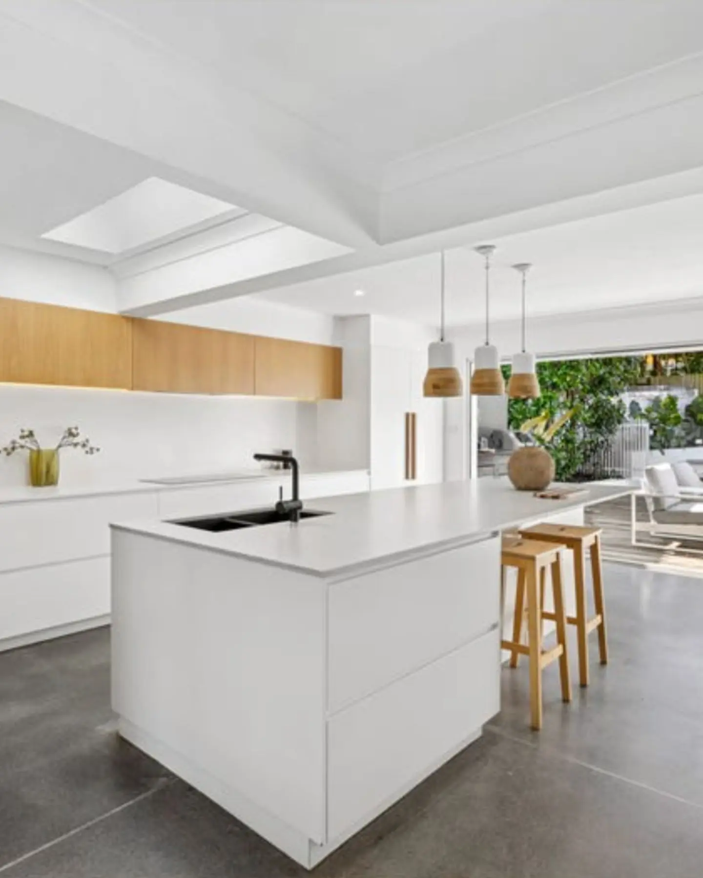 Contemporary white kitchen with a large island and high-end finishes, typical of the quality renovated homes we are seeking to buy for our clients