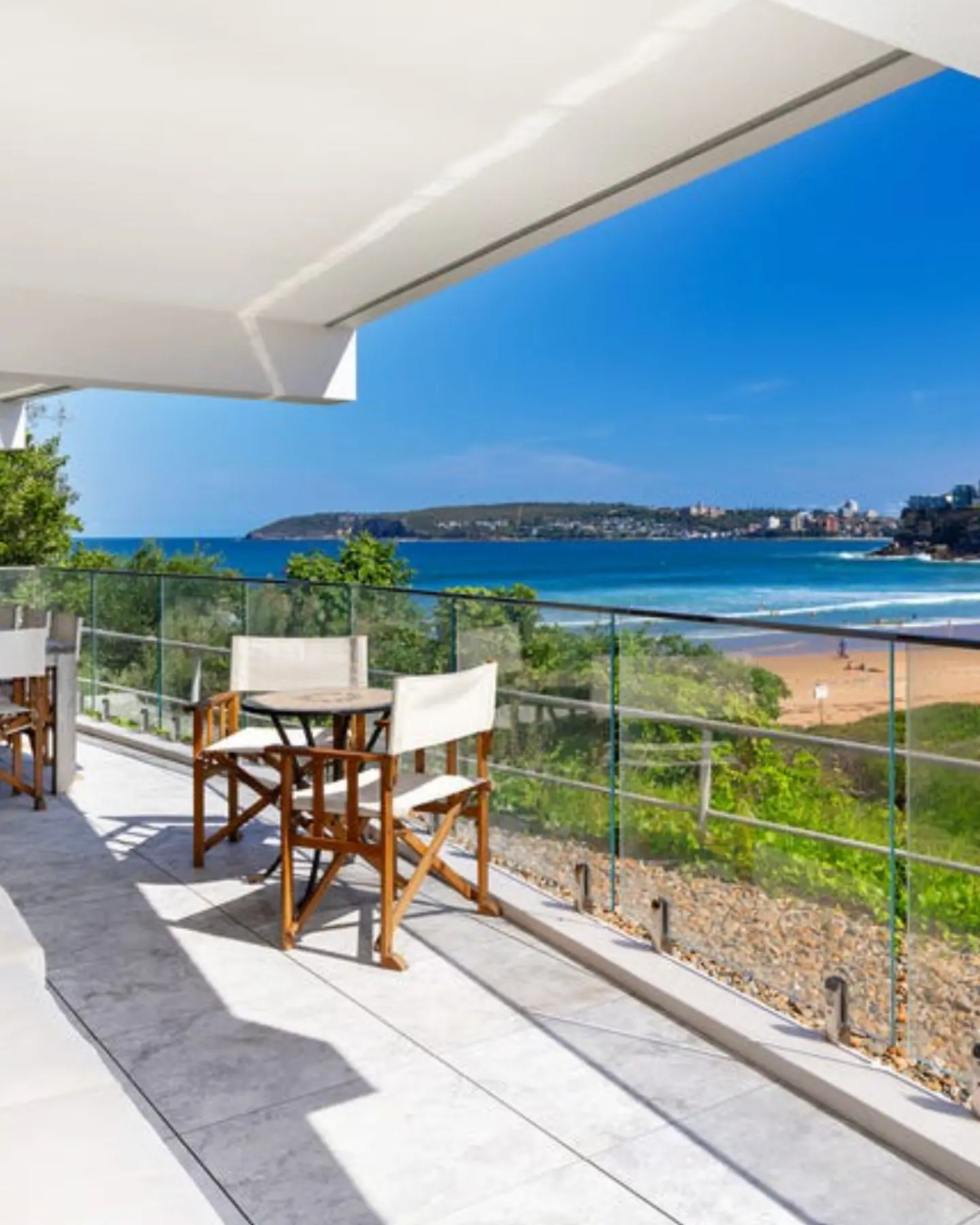 Sunlit balcony with a dining set and panoramic water views, showcasing the premium lifestyle properties our agency acquires
