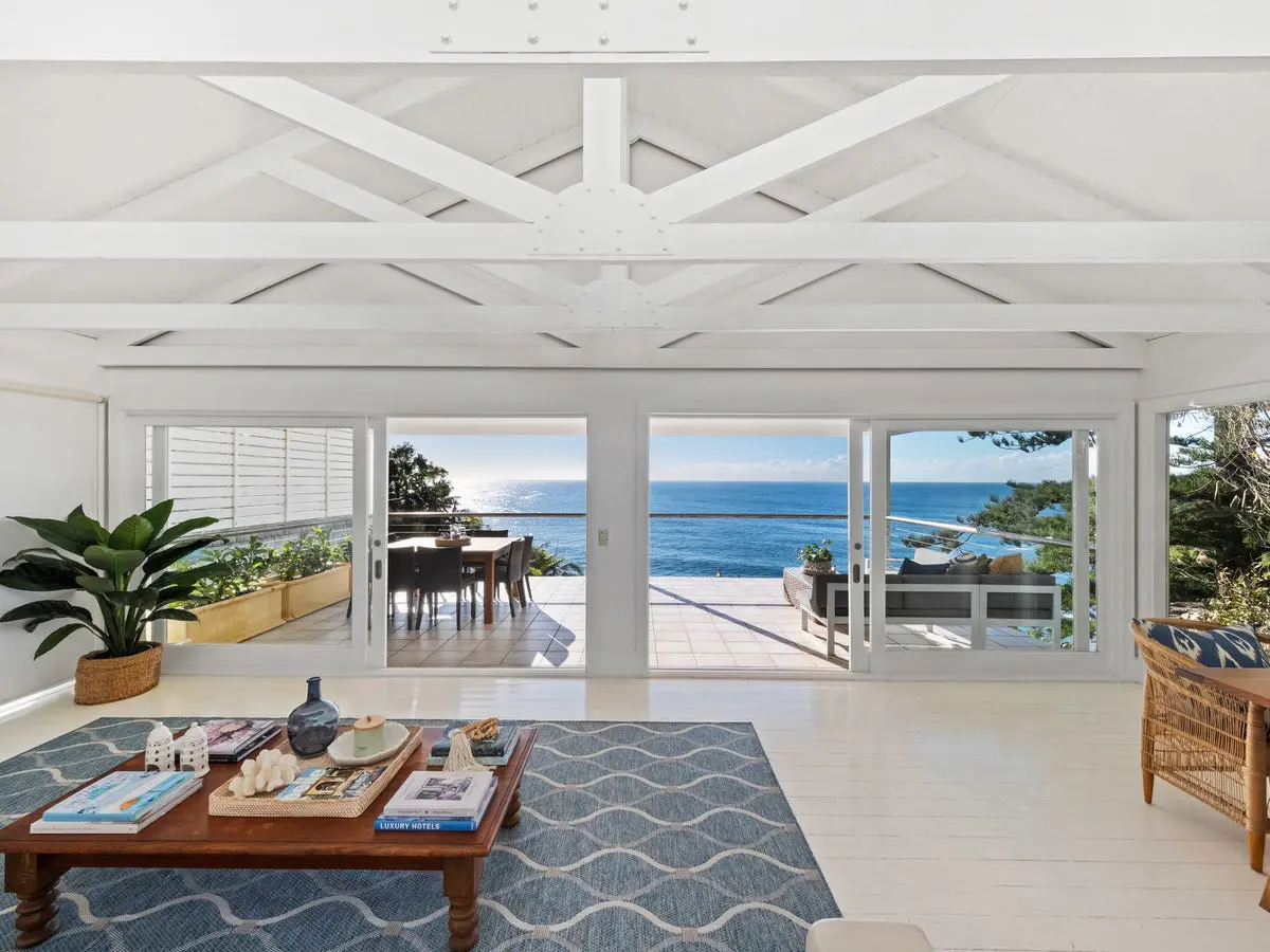 Living room opening to an ocean-view terrace at a house on Whale Beach Road, Whale Beach